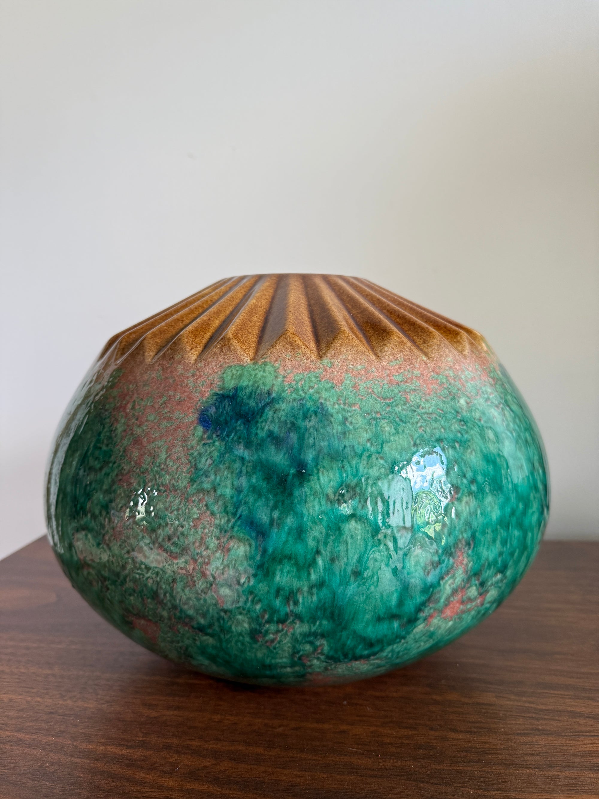 Decorative ceramic vase with green and brown glaze on a wooden surface mcm pottery statement bowl