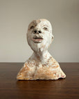 Ancient sculpture head on a plain background