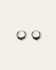A pair of small silver hoop earrings with textured, knotted details at the bottom, displayed on a solid off-white background.